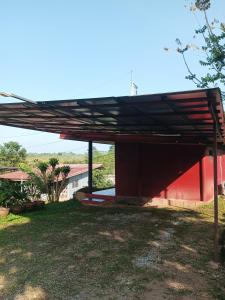 un bâtiment rouge avec toit au-dessus d'une cour dans l'établissement เขาค้อ อันนาอิม รีสอร์ท, à Ban Thung Samoe