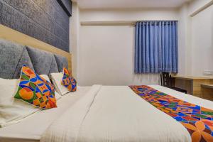 Vastral的住宿－FabExpress Canada，一间卧室配有一张带色彩缤纷枕头的大床