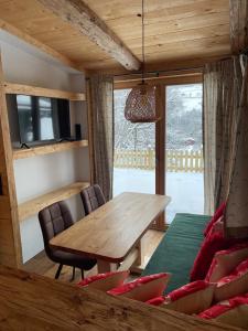 a dining room with a wooden table and chairs at Chaleny - Das erste Tiny House Chalet im Zillertal in Hainzenberg +6 photos