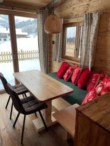 Habitación con cama y mesa con almohadas rojas. en Chaleny - Das erste Tiny House Chalet im Zillertal en Hainzenberg