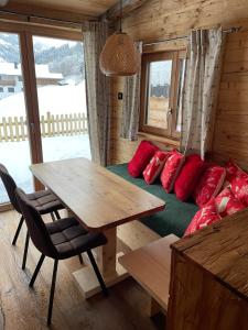 海因岑貝格的住宿－Chaleny - Das erste Tiny House Chalet im Zillertal，客房配有一张床铺和一张带红色枕头的桌子。