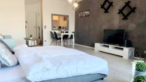 a bedroom with a large white bed and a flat screen tv at ✪ Beautiful Studio in Center with Amazing View ✪ in Mannheim