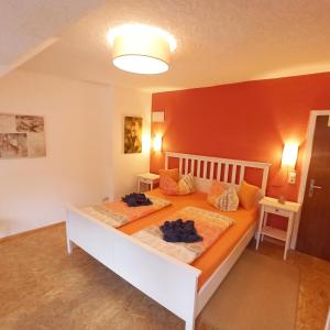 a bedroom with two beds and a red wall at Wohnen über den Dächern der Cochemer Altstadt in Cochem
