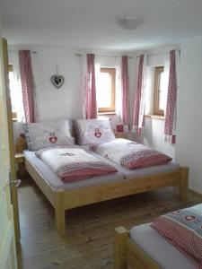 1 dormitorio con 2 camas y 2 ventanas en Haus Elfriede, en Schwendau