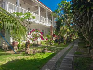 ein Haus mit Bäumen und Pflanzen im Hof in der Unterkunft Nhat Quang Bungalow in Mui Ne