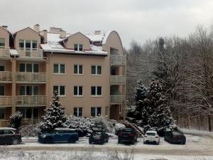 a large building with cars parked in a parking lot at Leśny Loft in Gdynia