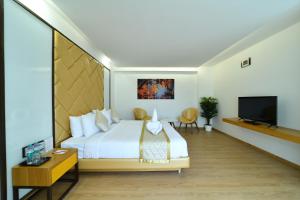 a hotel room with a bed and a flat screen tv at The President Hotel, kumarapark in Bangalore