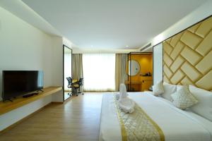 a hotel room with a large bed and a flat screen tv at The President Hotel, kumarapark in Bangalore