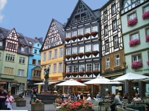 a group of people sitting at tables in front of buildings at Wohnen über den Dächern der Cochemer Altstadt in Cochem