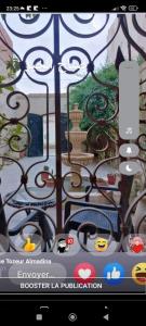 a window with a view of a garden through a gate at Residence Tozeur Almadina in Tozeur