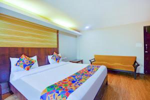 a bedroom with a large bed and a chair at FabExpress Ocean Residency, Colva in Colva