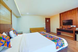 a hotel room with a large bed and a television at FabExpress Ocean Residency, Colva in Colva