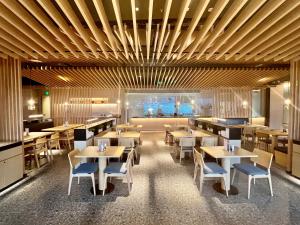 a restaurant with wooden ceilings and tables and chairs at Wyndham Shanxi Xiaohe Xincheng in Taiyuan
