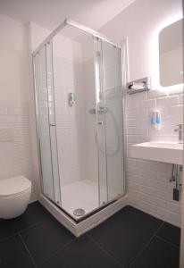 a bathroom with a shower and a toilet and a sink at Hotel Apadana Frankfurt in Frankfurt/Main +22 photos