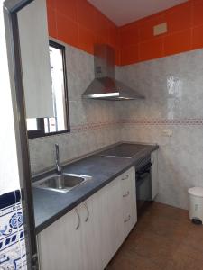 una pequeña cocina con fregadero y ventana en Almodovar Alojamientos en Almodóvar del Río