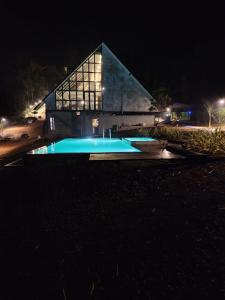 a building with a swimming pool at night at Nammal Resorts in Padinjarathara