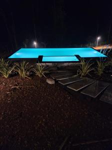 Nammal Resorts في Padinjarathara: حمام سباحة أزرق كبير في الليل
