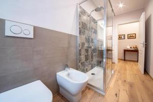 La salle de bains est pourvue de toilettes, d'un lavabo et d'une douche. dans l'établissement Residenza Vicolo Bovi Assisi, à Assise