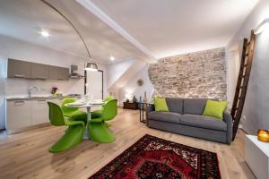 Il dispose d'une cuisine et d'un salon avec une table et des chaises vertes. dans l'établissement Residenza Vicolo Bovi Assisi, à Assise