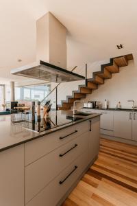 a kitchen with white cabinets and a staircase at Bishops View, Villa in Cape Town