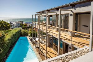 uma vista para uma casa com uma piscina e o oceano em Bishops View, Villa na Cidade do Cabo