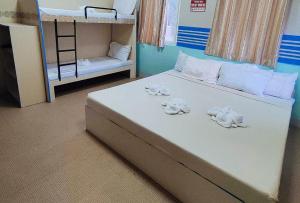a bedroom with a bed with two bunk beds at RedDoorz @ Isabelle Tourist Hotel Hinatuan in Hinatuan