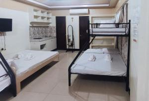 two bunk beds in a room with a kitchen at RedDoorz @ Isabelle Tourist Hotel Hinatuan in Hinatuan