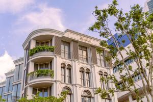 een groot wit gebouw met een balkon bij The Salil Hotel Riverside Bangkok in Bangkok