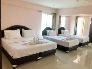 two beds in a hotel room with towels on them at Seksiri in Udon Thani +7 photos