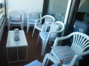 Sur la plage, vue sur mer, spacieux T3 au calme في سان سيبريان: مجموعة من الكراسي البيضاء وطاولة في الغرفة