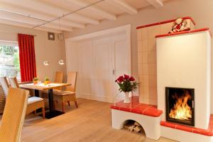 a living room with a fireplace and a table at Merker's Hotel & Restaurant Bostalsee in Bosen-Eckelhausen