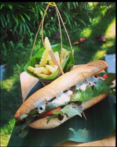 a sandwich with lettuce and cheese and a basket of fries at Paradise Cottage in Ko Chang