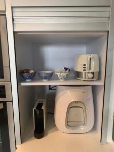 a refrigerator with a toilet and some bowls on a shelf at סוויטה מדהימה במרכז הארץ-amazing suite in the center of the country in Beʼer Ya‘aqov