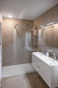 a bathroom with a white sink and a shower at Casselbergh Residences Petunia - De Haan in De Haan