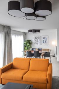 sala de estar con sofá naranja y mesa en Casselbergh Residences Petunia - De Haan en De Haan