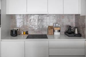 a kitchen with white cabinets and a counter top at Casselbergh Residences Petunia - De Haan in De Haan