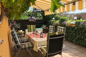 stół i krzesła na patio z roślinami w obiekcie Pension Biewer w mieście Ockfen