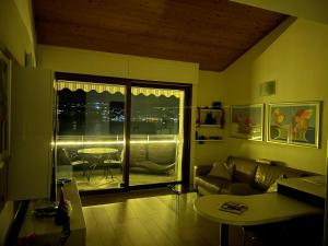 a living room with a couch and a table and a window at Bellavista Giulia on Lake Como in Dervio