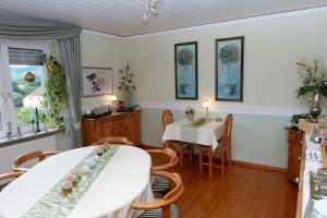 une salle à manger avec deux tables et une cuisine dans l'établissement Pension Biewer, à Ockfen