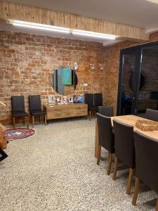 a living room with a brick wall and tables and chairs at Agro Guesthouse Korena in Kutaisi