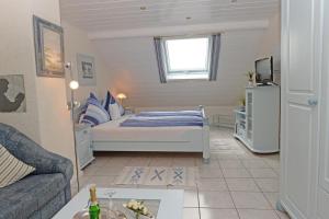 um pequeno quarto com uma cama e um sofá em Pension Biewer em Ockfen