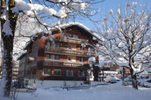 un grande edificio nella neve con alberi innevati di Dorfgasthof Adler a Mellau