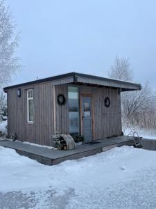 uma pequena casa com um alpendre na neve em Dzintarkrasts em Jūrmala