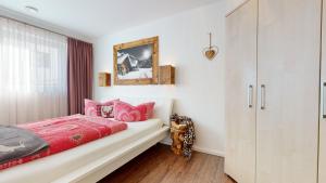 a bedroom with a red bed and a cabinet at Apartment LANDECK-CITY in Landeck
