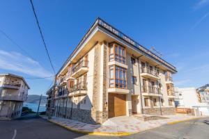 un gran edificio al lado de una calle en Apartagal-Mar de Vicedo en O Vicedo