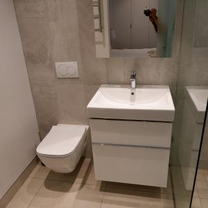 a bathroom with a white sink and a toilet at 117 on Strand - Luxury Apartments in Cape Town
