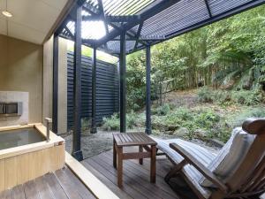 a patio with a chair and a table and a tub at Fufu Atami in Atami