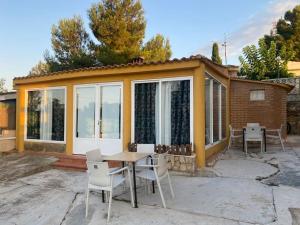 a small house with a table and chairs at Encantador alojamiento con acceso a piscina compartida in Monserrat