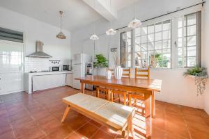 una cucina e una sala da pranzo con tavolo e panca in legno di Taitung Homeabout Pet Friendly Hall a Città di Taitung