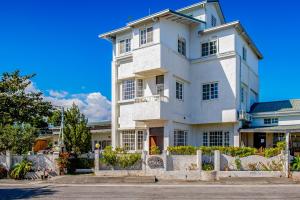 una casa bianca con una recinzione di fronte di Taitung Homeabout Pet Friendly Hall a Città di Taitung